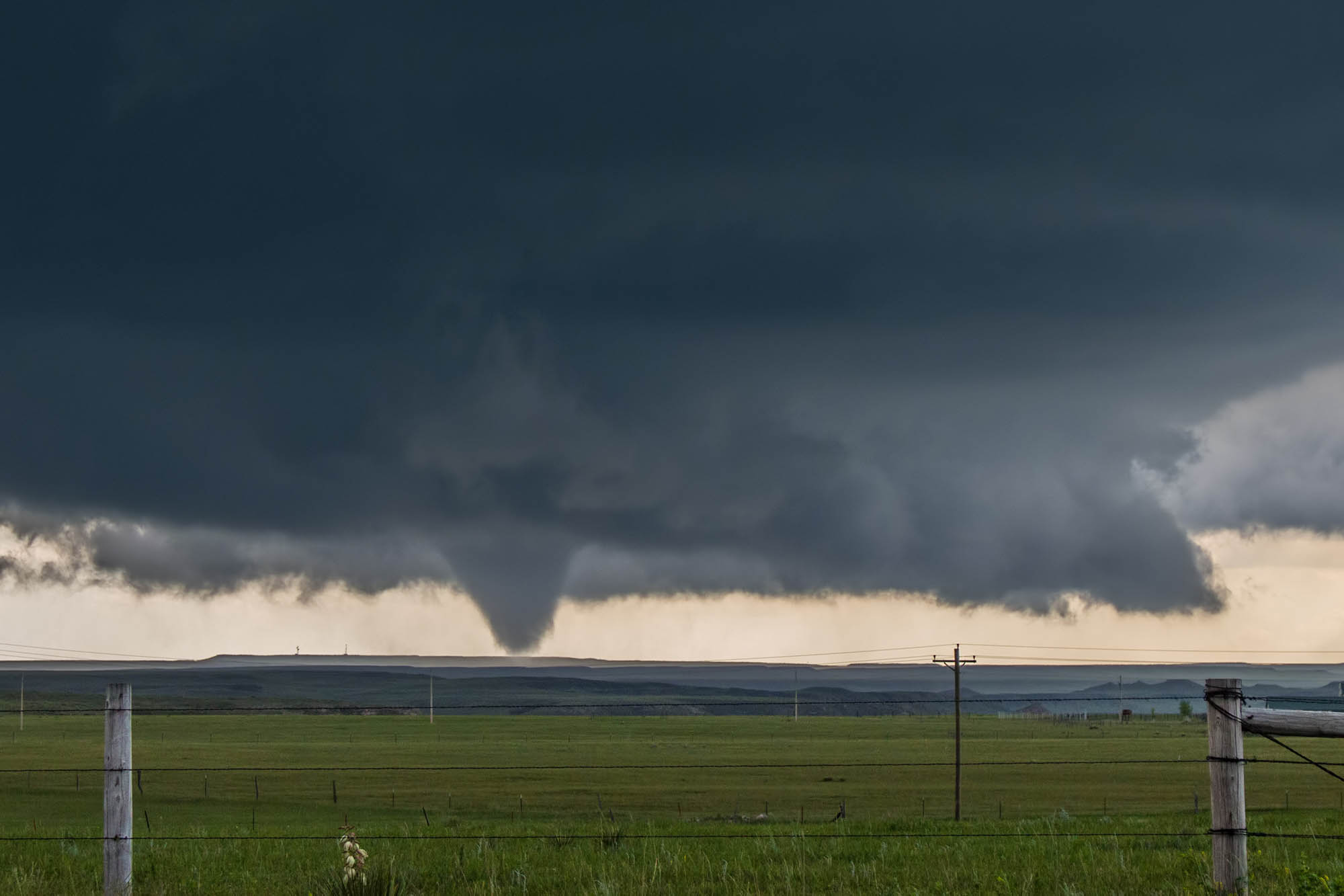Tornado forming over open countryside field