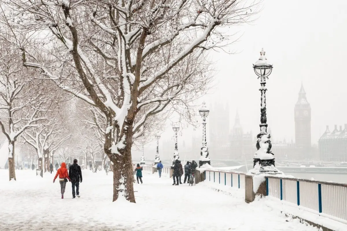 Pessoas caminhando na neve em Londres, perto do Big Ben.