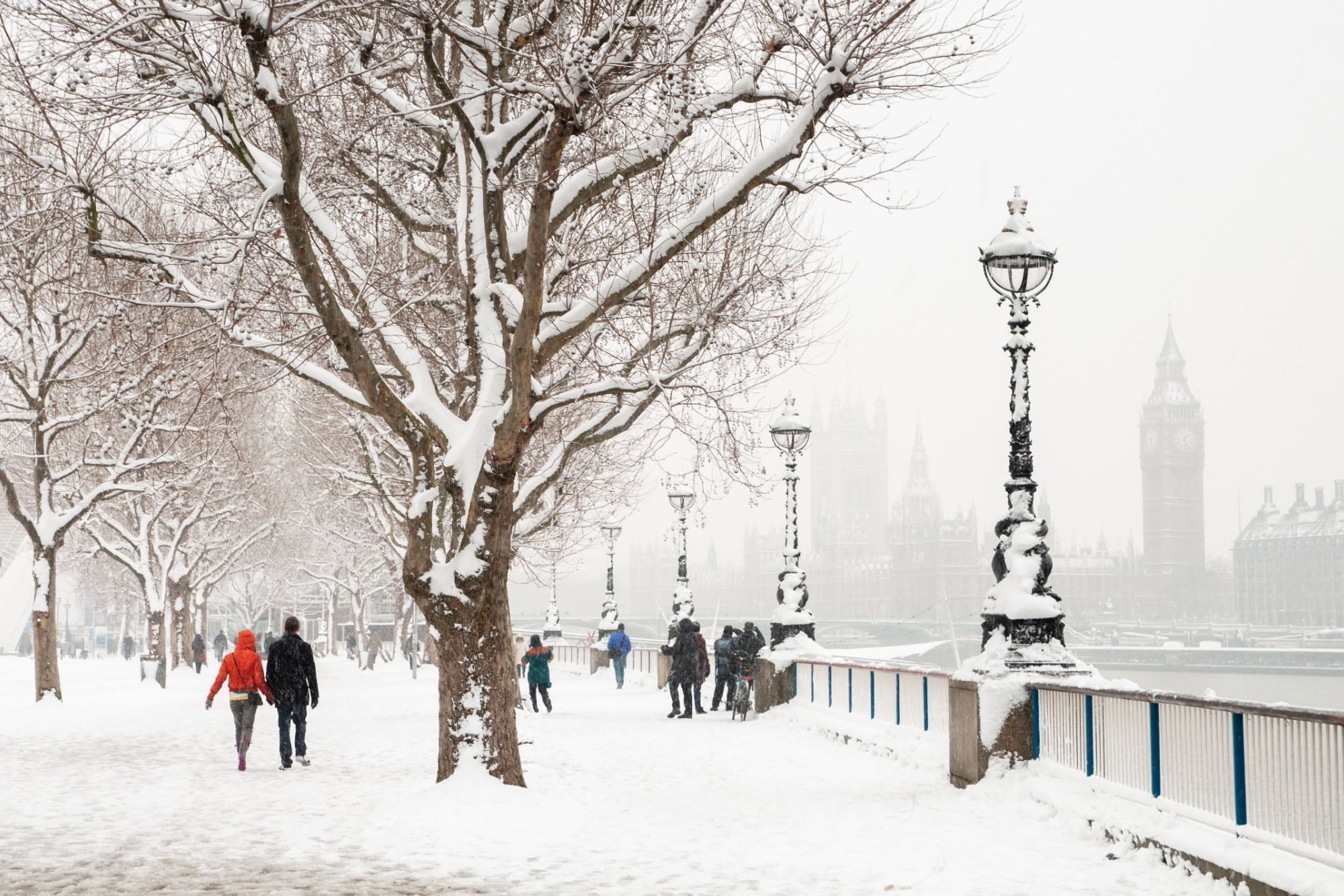 People walking in snowy London near Big Ben.