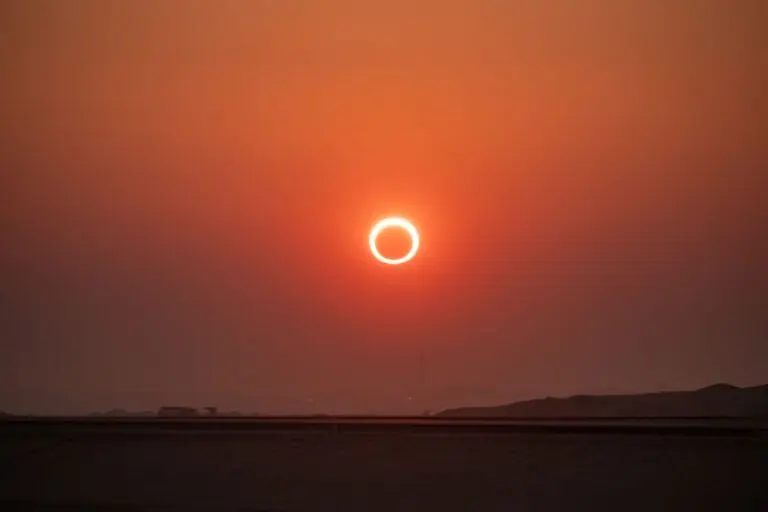 Eclipse solar durante o pôr do sol em uma paisagem de silhueta.