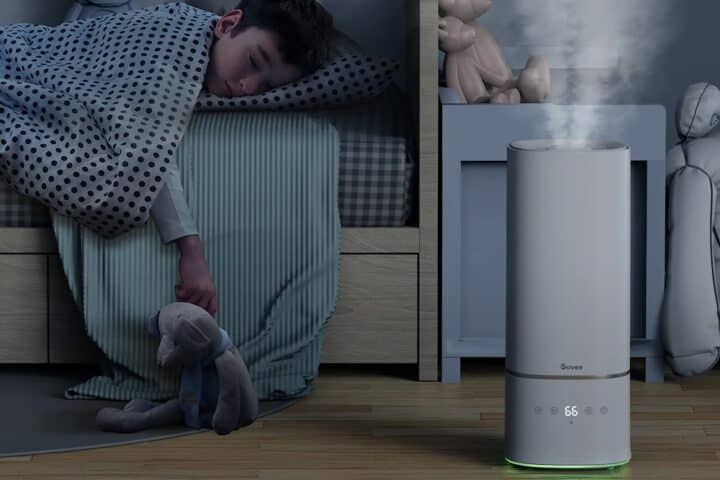 Child sleeping with a humidifier nearby in the bedroom.