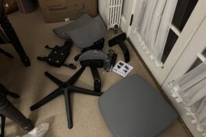 Unassembled ergonomic chair parts on the floor